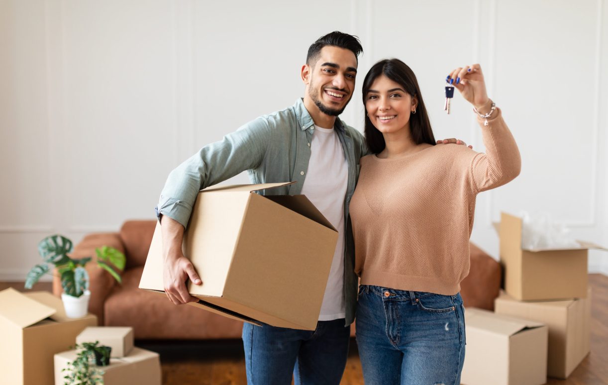 House,Ownership.,Young,Couple,Showing,Keys,And,Holding,Cardboard,Box,